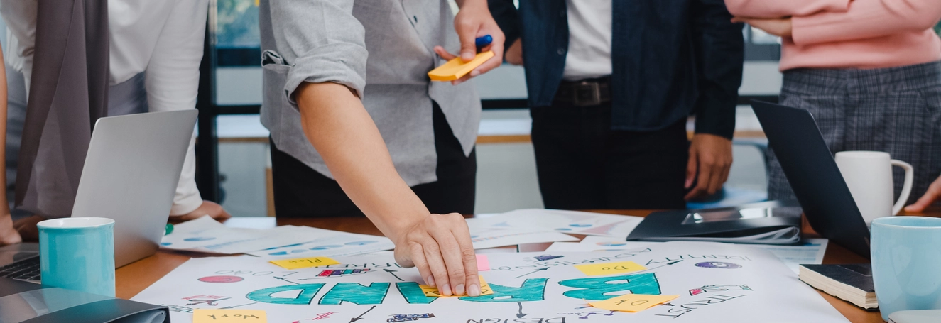 "jovens-empresarios-e-empresarias-asiaticos-felizes-reunindo-se-com-ideias-sobre-um-novo-projeto-de-papelada"